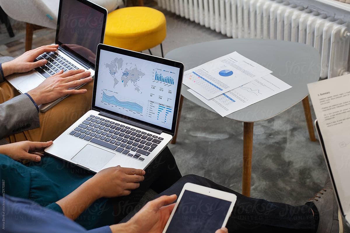 People surrounded by screens, charts, and printed reports